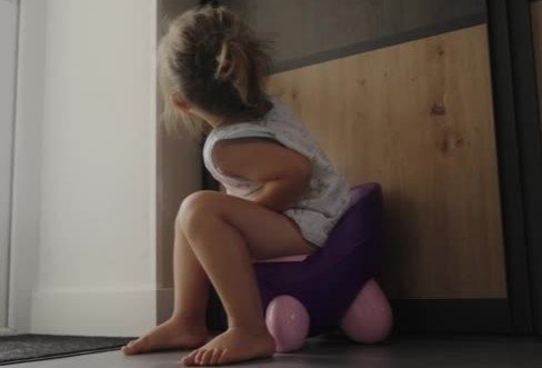 Criança feliz no troninho dando high-five na mãe